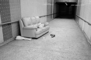 a photo of a derilict sofa in a hallway